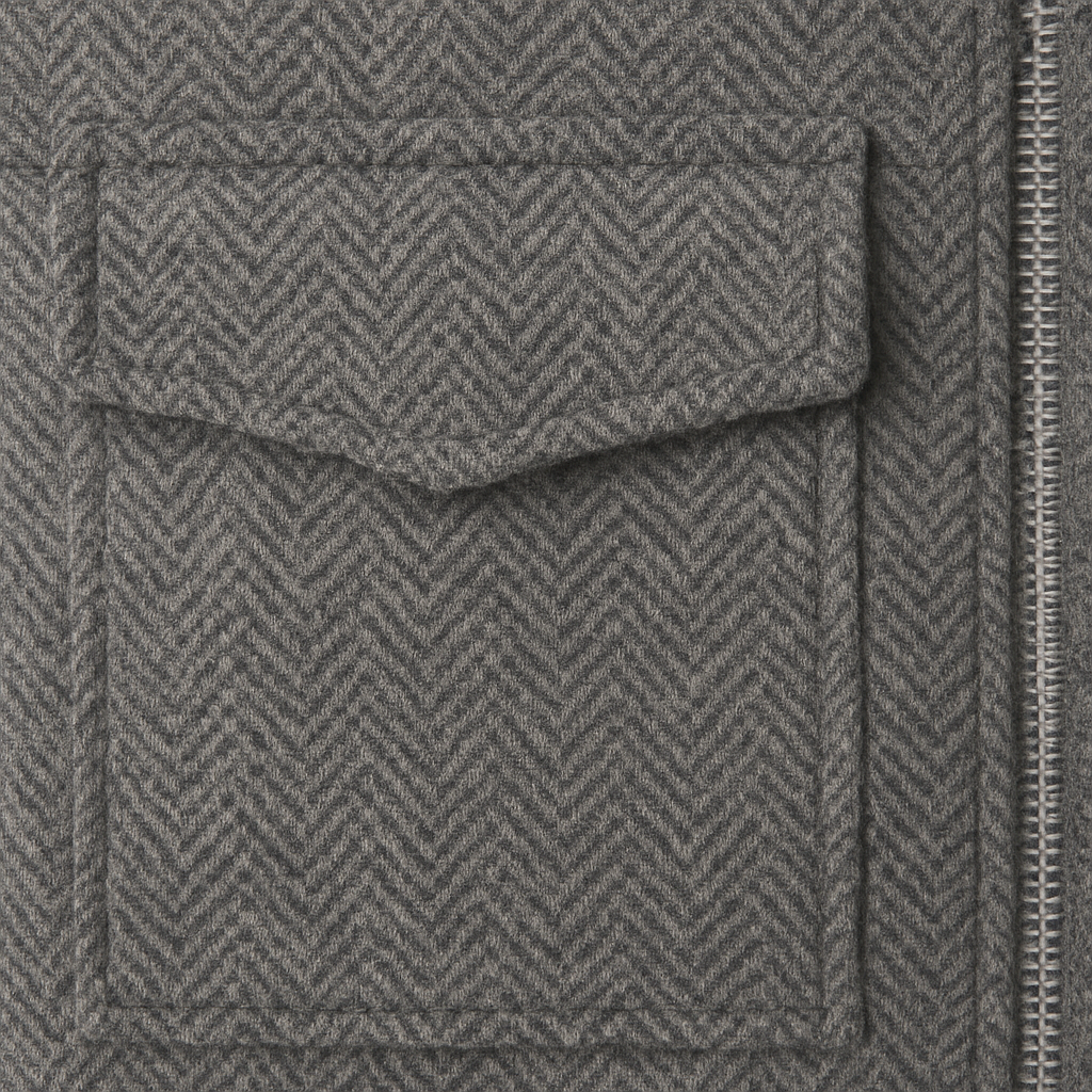 Cropped grey herringbone jacket with front zip closure, stand collar, and utility-style flap pockets.