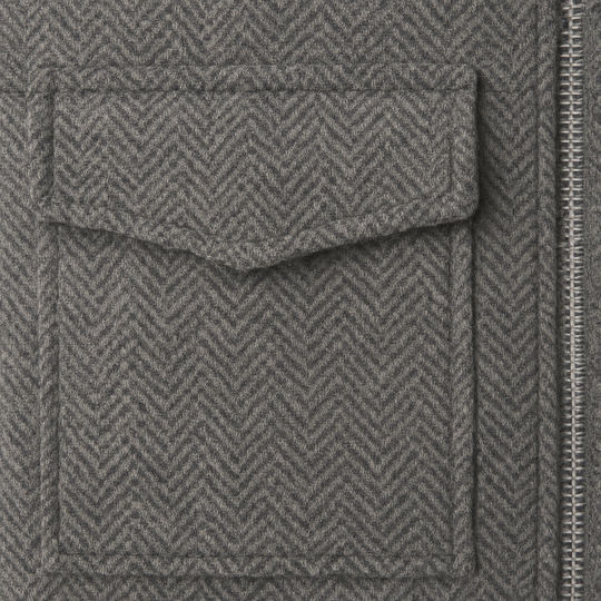 Cropped grey herringbone jacket with front zip closure, stand collar, and utility-style flap pockets.